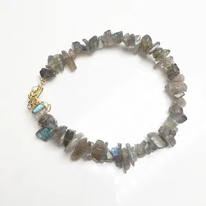 Detailopname van natuurlijke labradoriet armband met gouden karabijnsluiting