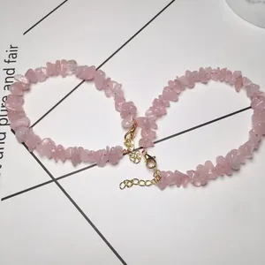 Detail of pink crystal stone bracelets with gold lobster clasp and round pendant charm