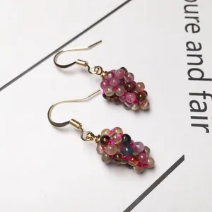 Macro detail of colorful tourmaline grape cluster earrings with gold metal hooks