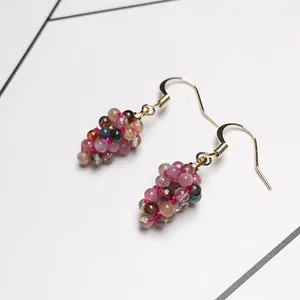 Detail of colorful tourmaline grape cluster earrings with handcrafted golden hooks