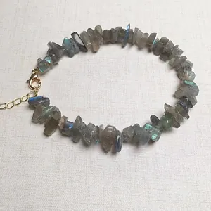 Macro-opname van natuurlijke labradoriet armband met verstelbare gouden karabijnsluiting