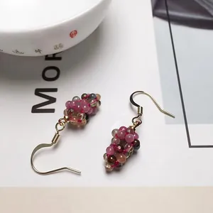 Detailed macro view of grape-shaped drop earrings with colorful tourmaline beads