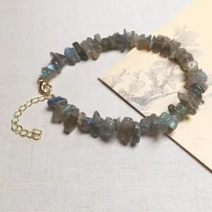 Detailopname van natuurlijke labradoriet armband met gouden karabijnsluiting en verlengketting