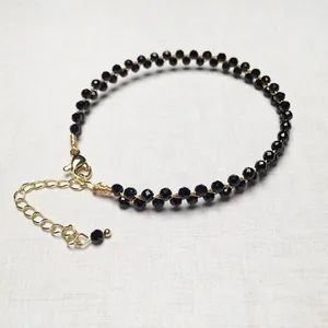 Detailed view of handcrafted black beaded bracelet with gold lobster clasp and chain