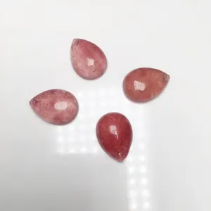 Primo piano di quattro ciondoli in quarzo fragola a goccia con venature naturali