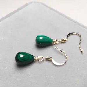 Eleganti orecchini a goccia in malachite con ganci dorati su espositore di lusso