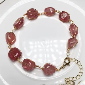 Bracelet en quartz fraise fait main avec fil d'or 14K sur un plat en porcelaine blanche