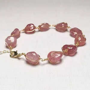 Vue détaillée des pierres de quartz fraise avec enroulement artisanal en fil doré 14 carats