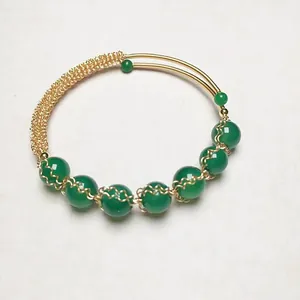 Detailed view of 14K gold-filled wire-wrapped bangle with seven green agate beads