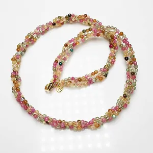 Vue macro d'un collier de perles de tourmaline multi-rangs avec un fermoir mousqueton doré
