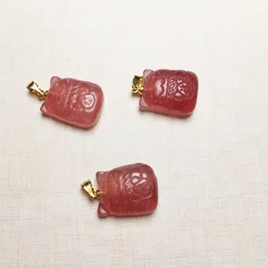 Vue rapprochée de trois pendentifs Maneki-neko en cristal fraise rose avec fermoirs dorés