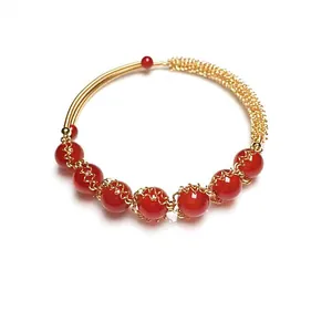 Detailed view of red agate beads wrapped in 14K gold-filled wire on an open bangle