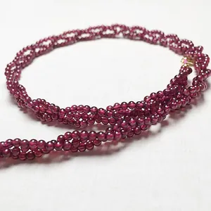 Détail macro d'un collier de perles de grenat rouge foncé à plusieurs rangs polis