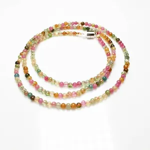 Detailed macro view of multi-color rainbow tourmaline beads with silver metal clasp