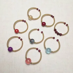Detailed view of eight handmade 14K gold wire wrapped rings with colorful crystal beads