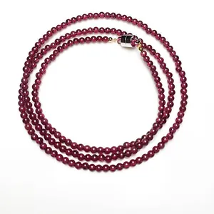 Detailed view of triple-layer garnet bead bracelet with a silver magnetic clasp closure