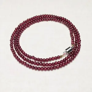 Macro view of multi-layer deep red garnet bead bracelet with magnetic metal clasp