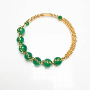 Detailed view of green agate beads and intricate 14K gold wire mesh on a handmade bracelet