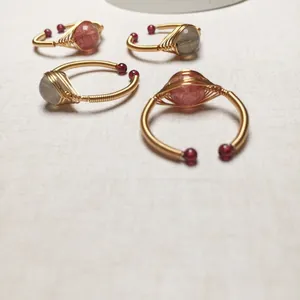 Detail von vier handgefertigten 14K golddrahtumwickelten Ringen mit Erdbeerquarz und Labradorit