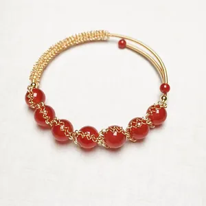 Macro shot of 14K gold-filled wire wrapped red agate beaded bracelet detail