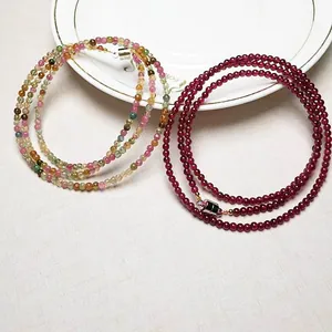Detail of multi-strand garnet and tourmaline bead bracelets with silver magnetic clasp