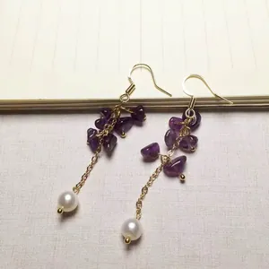 Detailansicht der Amethyst-Ohrhänger mit goldenen Ketten und weißen Perlen