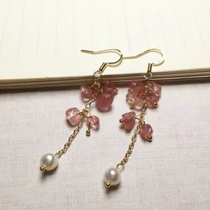 Details handgefertigter Goldohrringe mit rosa Erdbeerquarz und echten Süßwasserperlen