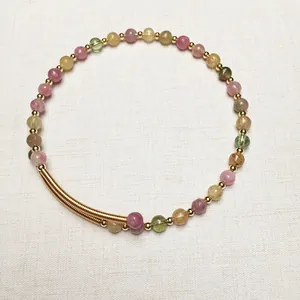 Détail d'un bracelet en perles de tourmaline colorées avec accents en spirale dorée