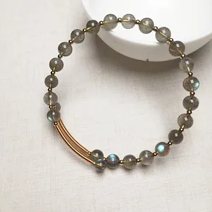 Vue macro du bracelet en perles de labradorite avec reflets bleus et détails dorés
