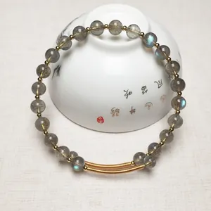 Bracelet en perles de labradorite aux reflets bleus et détails en or 14K sur support céramique