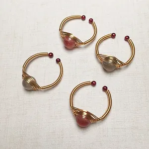 Detailansicht handgefertigter Ringe mit 14K Golddraht-Umwicklung und Erdbeerquarz-Steinen