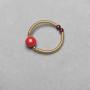Macro view of crystal ring with red beads and golden 14K wire wrap flexible band