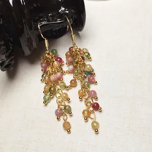 Dettaglio di orecchini a nappa lunga con perle colorate e ganci placcati in oro 14K
