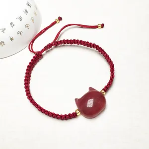 Handmade red cord bracelet with a cute strawberry quartz cat charm and gold accents