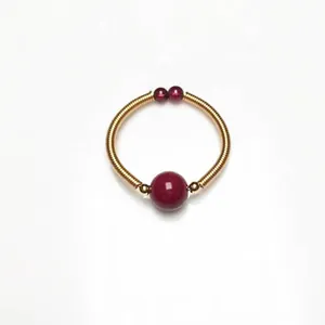 Detailed macro view of 14K gold wire-wrapped ring with deep red garnet beads