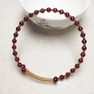 Détail du collier de perles en grenat avec fermoir doré 14K et entretoises sur céramique