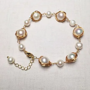 Macro detail of handmade 14K gold filled wire wrapped bird nest freshwater pearl bracelet