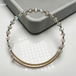 Macro detail of 14K gold-filled wire wrapped labradorite bead bracelet on jewelry tray