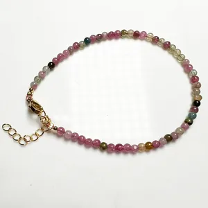 Détail d'un bracelet en perles de tourmaline colorées avec fermoir mousqueton doré