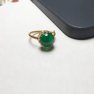 Detail eines handgefertigten Rings aus 14K Golddraht mit großem grünem Achat-Edelstein