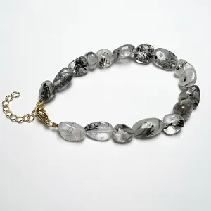 Detail of raw black rutilated quartz beads with 14K gold-plated adjustable clasp