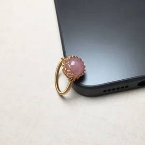 Detail eines handgefertigten Rings aus 14K Golddraht mit einer Rosenquarz-Perle