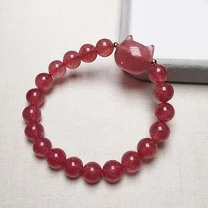 Detailed macro of strawberry quartz beaded bracelet with a cute cat head pendant