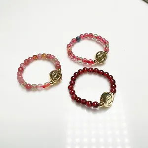 Beaded gemstone rings with garnet and tourmaline featuring gold plated coin charms