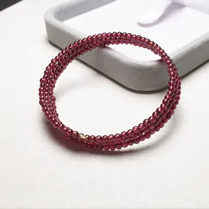 Détail d'un bracelet multi-rangs en grenat avec des perles polies rouge foncé
