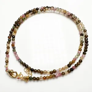 Détail de perles de tourmaline facettées avec fermoir mousqueton doré et chaînette