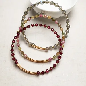 Gros plan de bracelets en pierres naturelles de grenat et tourmaline avec accents en or 14K