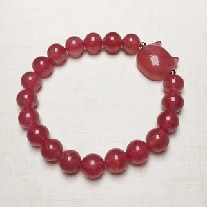 Detailed close-up of strawberry crystal bead bracelet featuring a cute pink fox charm