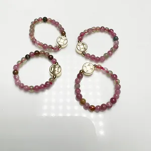 Tourmaline beaded ring with 14K gold plated coin pendant on white background