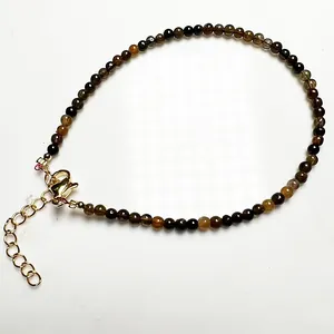 Détail d'un bracelet en perles de tourmaline colorées avec fermoir mousqueton doré réglable